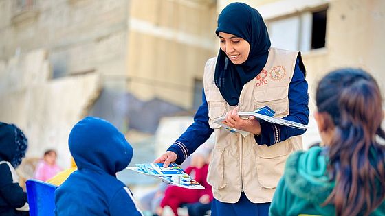 Hygieneschulung für Kinder Eine CARE-Mitarbeiterin unterrichtet Kinder zum Thema Hygiene und verteilt Unterrichtsmaterialien.